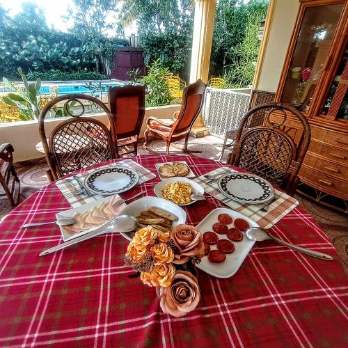 a table with a red table cloth with food on it at Paraíso Hortensia Honeymoon Suite in Santiago de los Caballeros