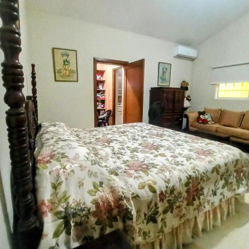 a bedroom with a bed with a floral bedspread at Paraíso Hortensia Honeymoon Suite in Santiago de los Caballeros