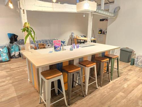 a kitchen with a island with bar stools at The Beach House ザ ビーチハウス