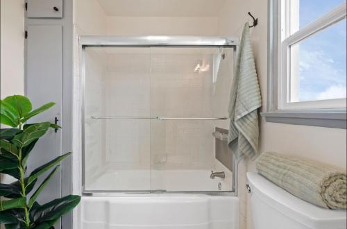 a shower with a glass door in a bathroom at Twilight Terrace - Telescope - 15 Min to Beach in Hawthorne