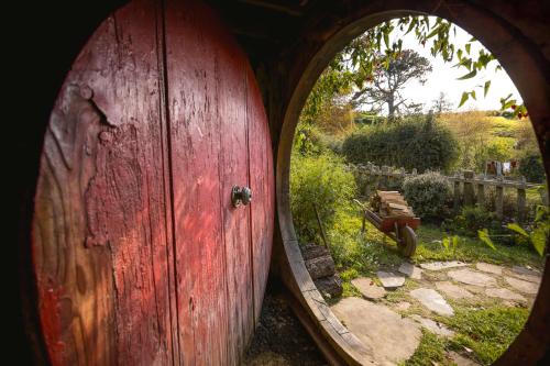 an open wooden door with a view of a garden at Matamata Lodge in Matamata