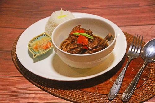a bowl of food on a plate on a table at Adriana's Place Tropical Guesthouse in Panglao