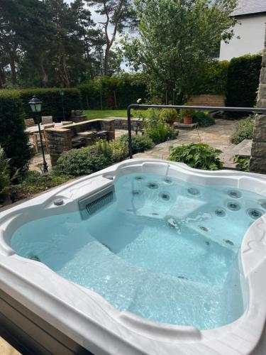 a jacuzzi tub in a garden at Greenacres Hall in Disley