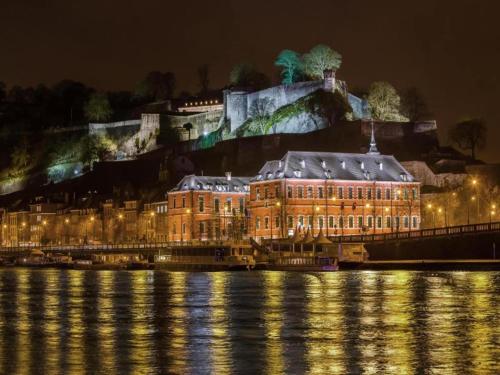 a large building on the water at night at Cozy Holiday Home in Gedinne near Forest in Vencimont