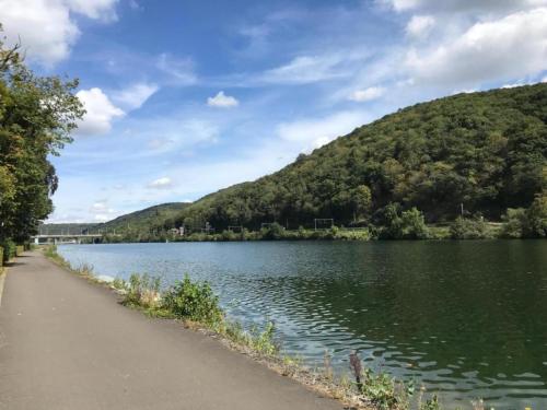 a lake with a path next to a mountain at Cozy Holiday Home in Gedinne near Forest in Vencimont