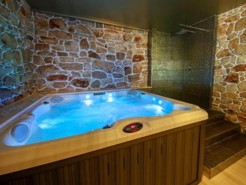 a large blue tub in a room with a stone wall at Villa Gabriel - Three Bedroom Villa with Outdoor Pool in Drniš