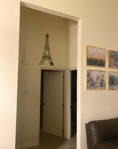 a clock on the wall of a room with the eiffel tower at 3Little Birds Retreat in Old Harbour