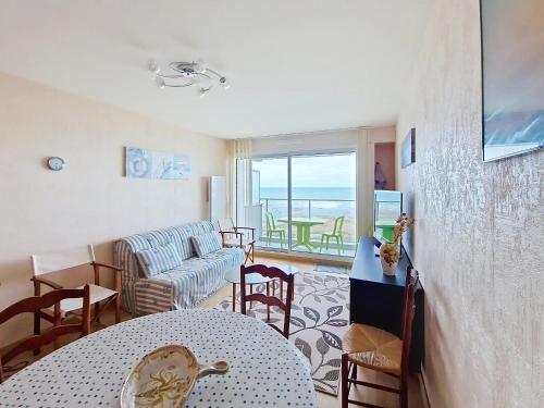un salon avec un canapé, une table et des chaises dans l'établissement Appartement T2 rénové face à la mer avec terrasse et garage - Quartier des Présidents - Les Sables-d'Olonne - FR-1-331-90, à Les Sables-dʼOlonne