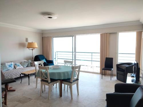 un salon avec une table et des chaises dans l'établissement T3 face mer avec balcon - 3ᵉ étage, 100 m du centre - 6 personnes - Garage - Plage au pied - FR-1-331-101, à Les Sables-dʼOlonne