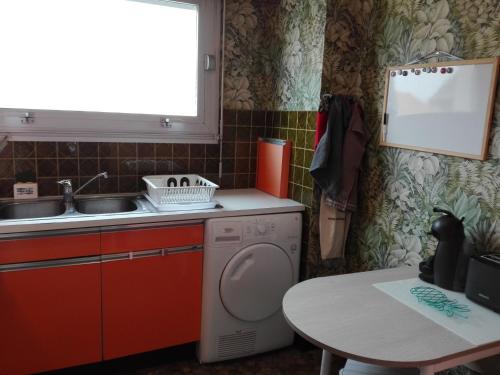 une petite cuisine avec un lave-linge et une table dans l'établissement T3 face mer avec balcon - 3ᵉ étage, 100 m du centre - 6 personnes - Garage - Plage au pied - FR-1-331-101, à Les Sables-dʼOlonne
