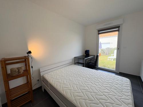une chambre avec un lit et une fenêtre dans l'établissement Maison neuve proche forêt, 2 chambres, parking privatif - FR-1-323-572, à Saint-Jean-de-Monts