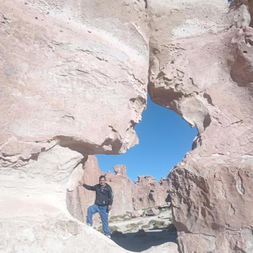 a man standing in a cave in a rock formation at acogedor y elegante departamento en uyuni in Uyuni