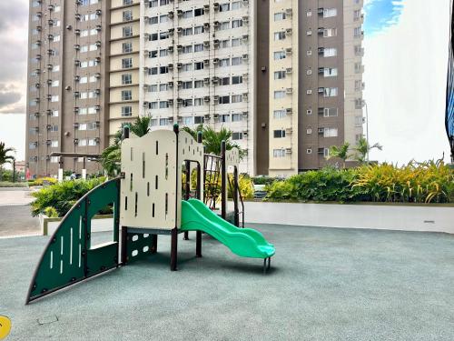 a playground in front of a large building at Pool View Cozy 1-Bedroom Unit Avida Aspira Tower 2 in Cagayan de Oro