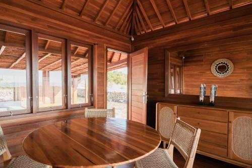 a wooden dining room with a wooden table and chairs at Villa Hestia in Memboro