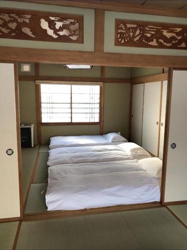 a bedroom with a bed in a room with a window at 小樽祝津山荘1号楼 in Otaru