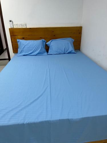 a large bed with blue sheets and pillows at Taprobane Resort in Trincomalee