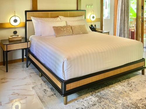 une chambre avec un grand lit dans une pièce dans l'établissement Karenina Agung Resort Semarang, à Gunungpati