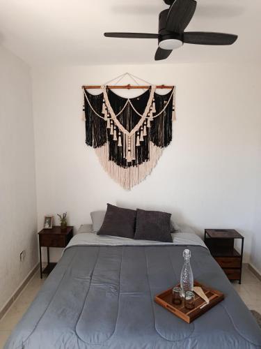 a bedroom with a bed with a black ceiling fan at Habitación privada en penthouse con roof top in Playa del Carmen
