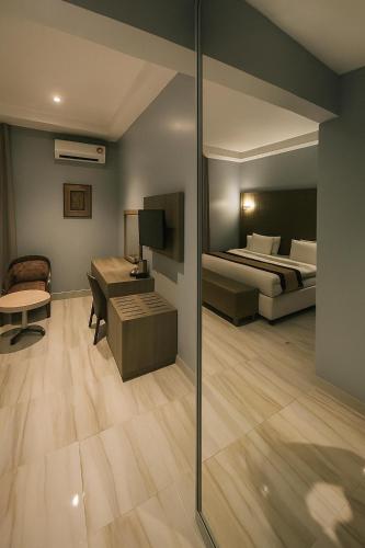 a bedroom with a bed and a room with a desk at Maxbe Continental Hotel in Awka