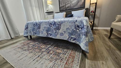 una camera con un letto con una coperta blu e un tappeto di Serenity Inn a Niagara Falls