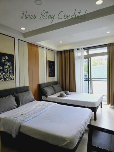 a hotel room with two beds and a couch at Pines Stay Condotel Megatower 4 Reception in Baguio