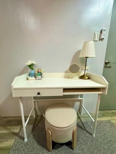 a white desk with a lamp and a stool at The Calm Nest by Luke and Nian in San Juan