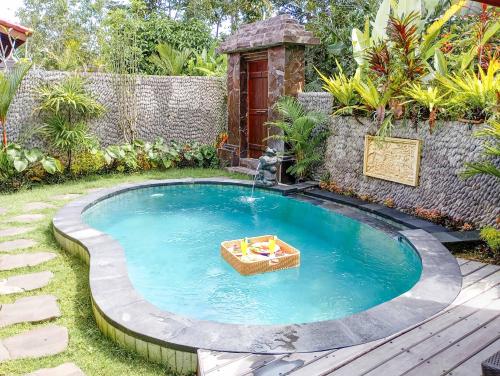 a small pool with a fountain in a yard at Anggi Villas Ubud in Tegalalang