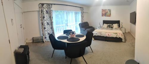 a room with a table and chairs and a bed at Hamilton Homestay in Hamilton