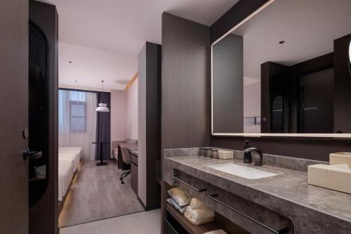 a bathroom with a sink and a mirror at Atour Hotel Suzhou Gusu Dongzhong in Suzhou