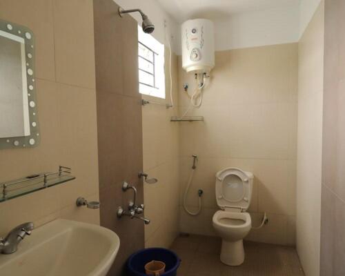 a bathroom with a sink and a toilet and a window at Maria villa in Ooty