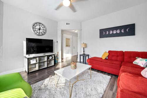 a living room with a red couch and a tv at Cozy Woodlawn Retreat 2 in Chicago