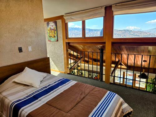 Un dormitorio con una cama y una ventana grande. en Villa Florita, en La Paz