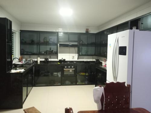 a kitchen with black cabinets and a white refrigerator at Casa mar in Maragogi