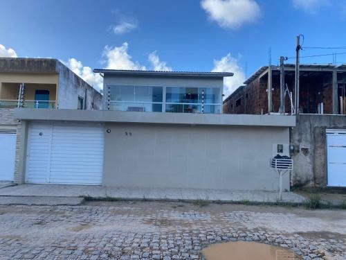 a house with two garage doors and a building at Casa mar in Maragogi