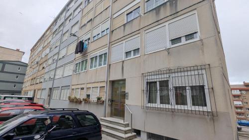 a large building with cars parked in front of it at Alojamiento Bajamar in Santander
