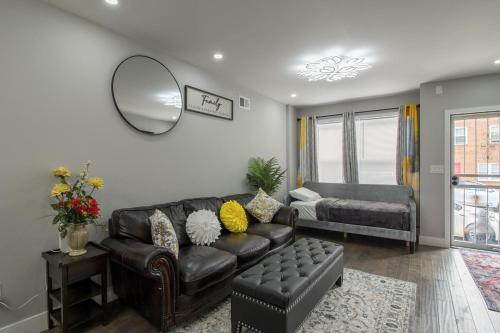a living room with a leather couch and a mirror at Home in Philadelphia Stadium nearby in Philadelphia