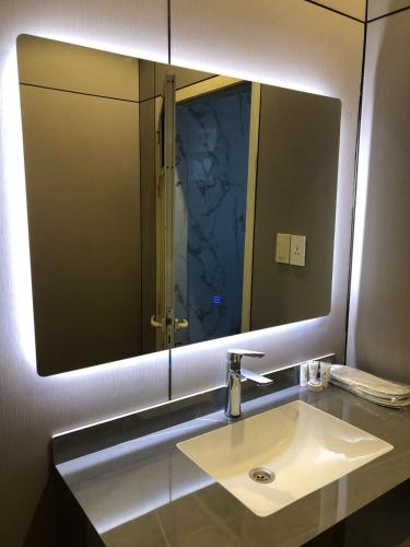 a bathroom with a sink and a large mirror at العنوان للشقق المخدومة ALanwaan of the units served in Dammam