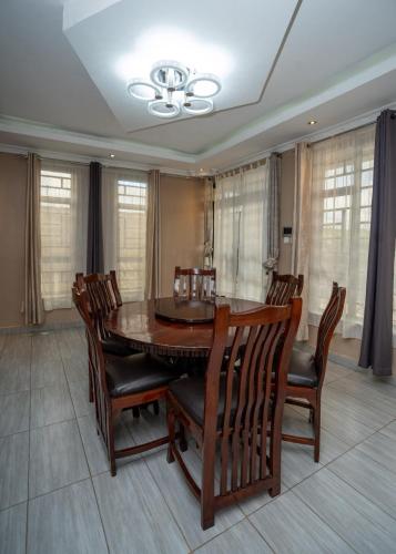 a dining room with a wooden table and chairs at Syokiton Private Home near JKIA Airport in Syokimau