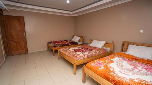 a room with two beds and a door at Syokiton Private Home near JKIA Airport in Syokimau