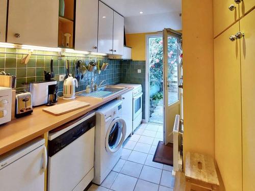 Il comprend une cuisine équipée d'un lave-linge et d'un sèche-linge. dans l'établissement Maison confortable Côte de Granit Rose avec parking - FR-1-542-75, à Trégastel