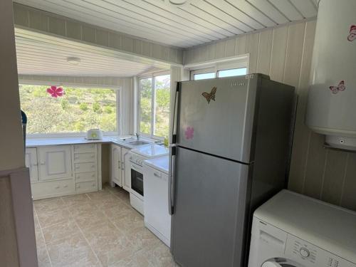 une cuisine avec un réfrigérateur blanc et une fenêtre dans l'établissement Appartement spacieux à Esparron pour 10 avec piscine - FR-1-822-20, à Esparron-de-Verdon