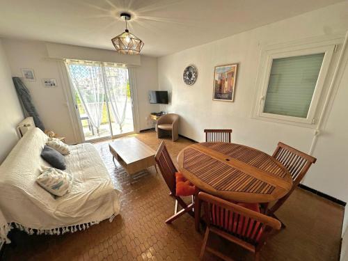 - un salon avec une table en bois, une table et des chaises dans l'établissement Appartement T3 à Collioure, 30m des plages, terrasse et parking - FR-1-309-520, à Collioure