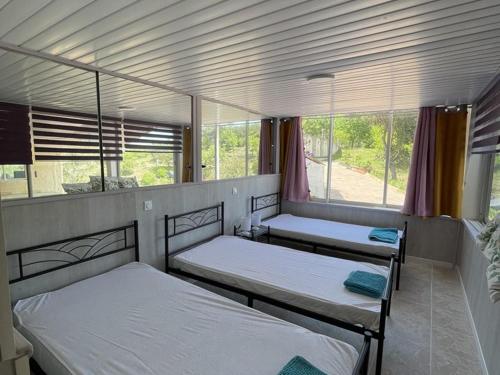 une chambre avec trois lits et une fenêtre dans l'établissement Appartement spacieux à Esparron pour 10 avec piscine - FR-1-822-20, à Esparron-de-Verdon