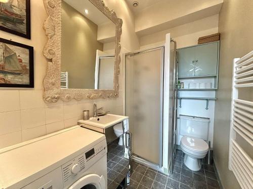 une salle de bain avec un lavabo, des toilettes et un miroir dans l'établissement Maison cosy 2 pièces avec jardinet, La Baule Centre - FR-1-245-216, à La Baule