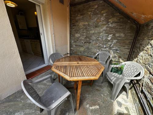 une table et des chaises en bois sur une terrasse dans l'établissement Appartement T3 à Collioure, 30m des plages, terrasse et parking - FR-1-309-520, à Collioure