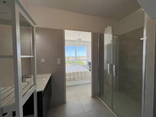 une salle de bain avec une douche en verre et un lavabo dans l'établissement Duplex de Standing pour 7 Pers. avec Terrasse et Parking à 500m de la Plage - FR-1-81-642, à Port-Leucate