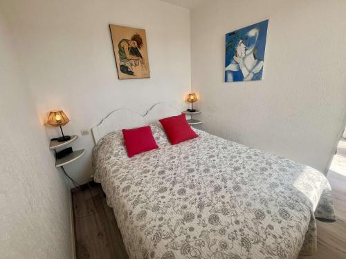 une chambre avec un lit avec deux oreillers rouges dans l'établissement Appartement 2 pièces, climatisé, parking privé à Cavalaire-sur-Mer - FR-1-226B-240, à Cavalaire-sur-Mer