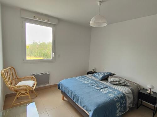 une chambre avec un lit, une fenêtre et une chaise dans l'établissement Appartement T2 proche plage avec terrasse, clim, Wi-Fi et parking - FR-1-781-102, à Valras-Plage