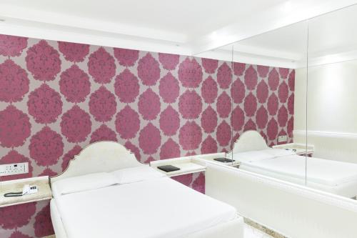 een kamer met 2 bedden en een roze muur bij Nosso Hotel (Adult Only) in Rio de Janeiro