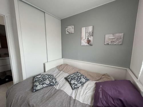 une chambre avec un lit avec deux oreillers dessus dans l'établissement Appt 2 pièces cabine avec piscine et parking, Port Camargue - FR-1-250-310, au Grau-du-Roi